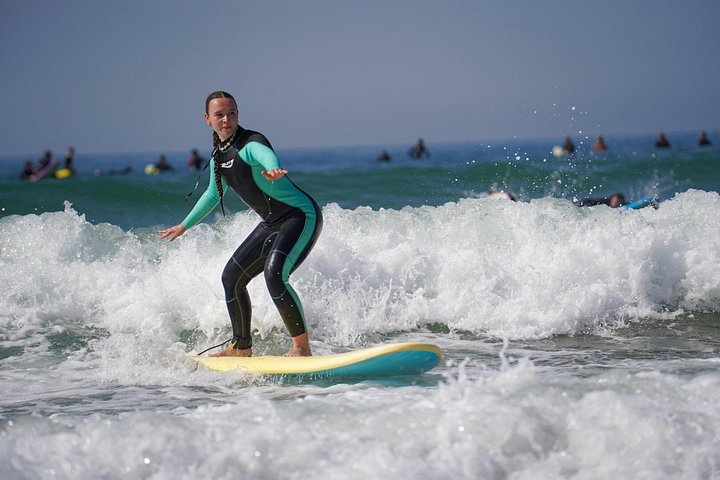 Surfeuse debout sur sa planche dans les vagues